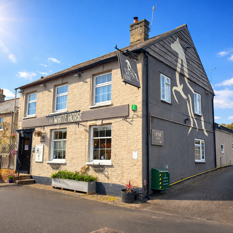 The White Horse pub, a beige building with a large white horse mural on its dark gray side.